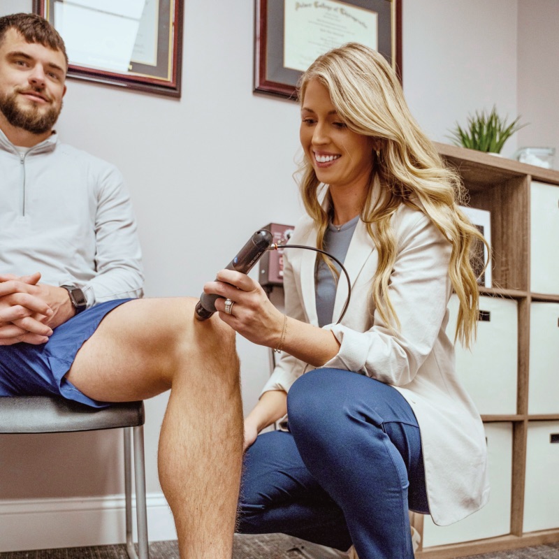 Dr. Gurbacki applies shockwave therapy to a patient's knee in her West Omaha clinic.